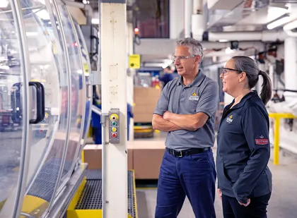 Two Sleeman Breweries employees observe production machinery in a collaborative and engaging work environment.